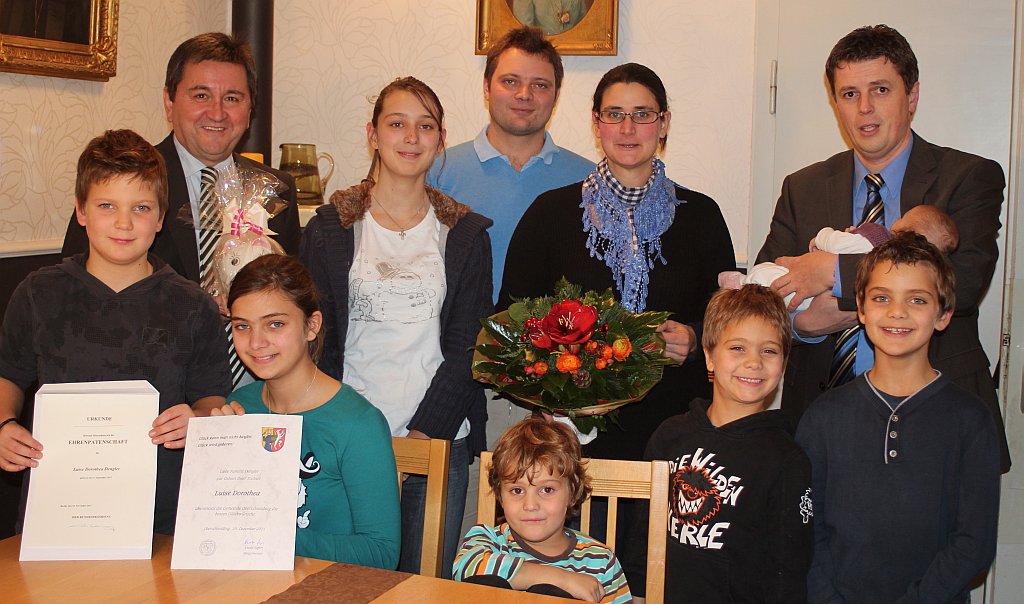 hintere Reihe: Landrat Alfred Reisinger, Maria, Eltern Peter und Katrin Dengler, Bürgermeister Ewald Seifert mit der kleinen Erdenbürgerin Luise Dorothea, die der Rummel um sich herum wenig interessiert  Vordere Reihe: Leonhard, Elisabeth, Luitpold, Bartholomäus und Josef