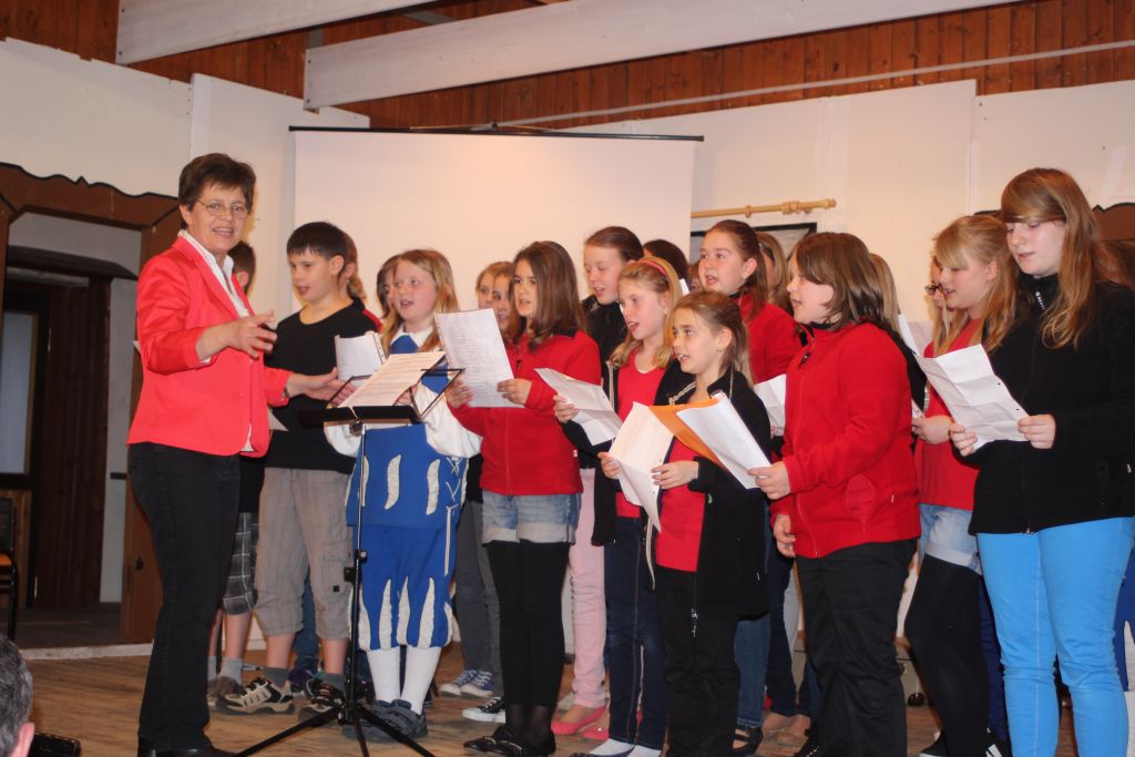 Ein Geburtstagsständchen zu Ehren von Pfarrer Peter Maier: Chorleiterin Frau Johanna Mühlbauer mit dem Junior Choir!