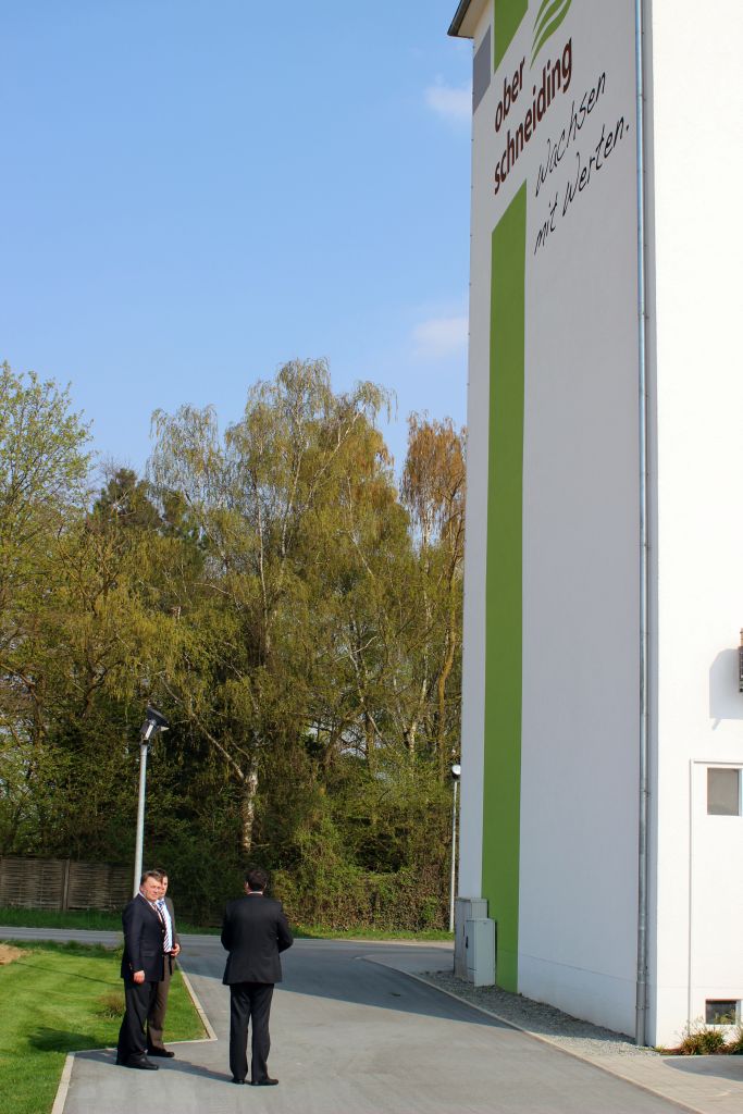 Landwirtschaftsminister Helmut Brunner, Bürgermeister Ewald Seifert und Leiter des Amtes für ländliche Entwicklung Roland Spiller vor dem ehemaligen Getreidespeicher mit dem Oberschneidinger Logo „Wachsen mit Werten“