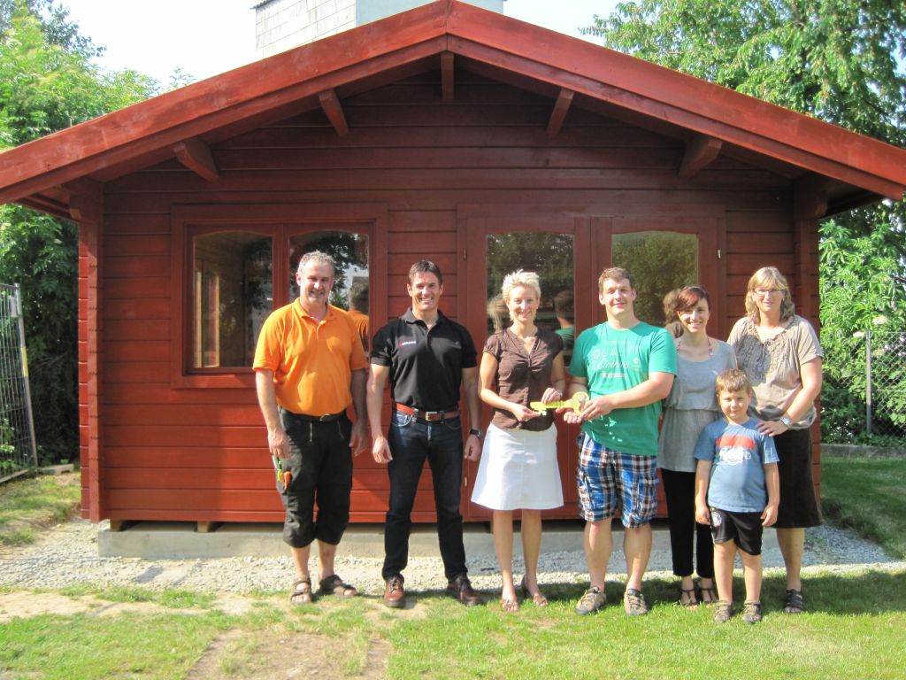 Das neue Gartenhäuschen mit den Spendern und der Kita-Leiterin