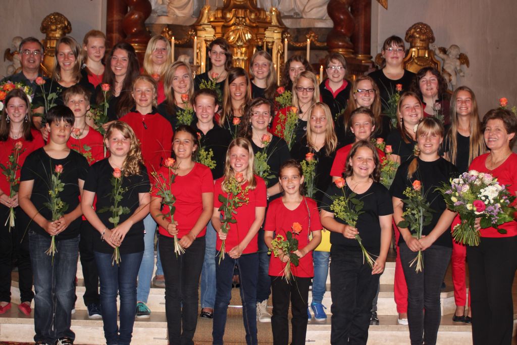Der strahlende Schneidinger Junior Choirs mit Chorleiterin Johanna Mühlbauer (rechts unten) und Pfarrer Dr. Peter Maier (links oben) 